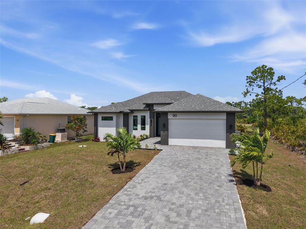 A modern single-story house with a gray shingled roof and a paved driveway — 90 BRIG CIRCLE S, PLACIDA, FL