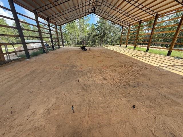 An open-sided pole barn structure with a metal roof stands on a sandy lot — 16386 KAKAWI ROAD, WEEKI WACHEE, FL