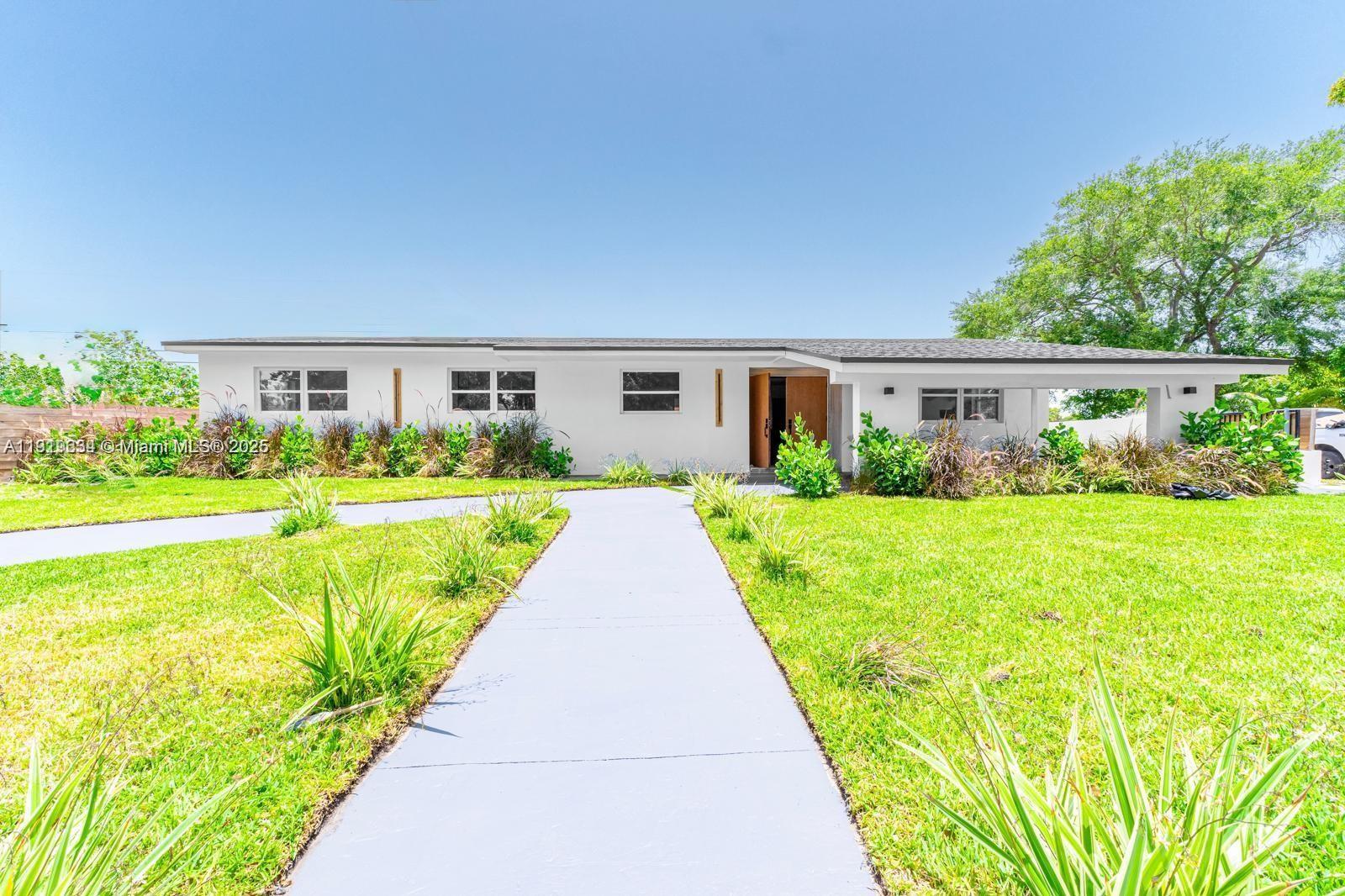 A single-story white house with a flat roof and a paved walkway in the yard — 19661 NE 10th Pl, Miami FL 33179, MIAMI, FL