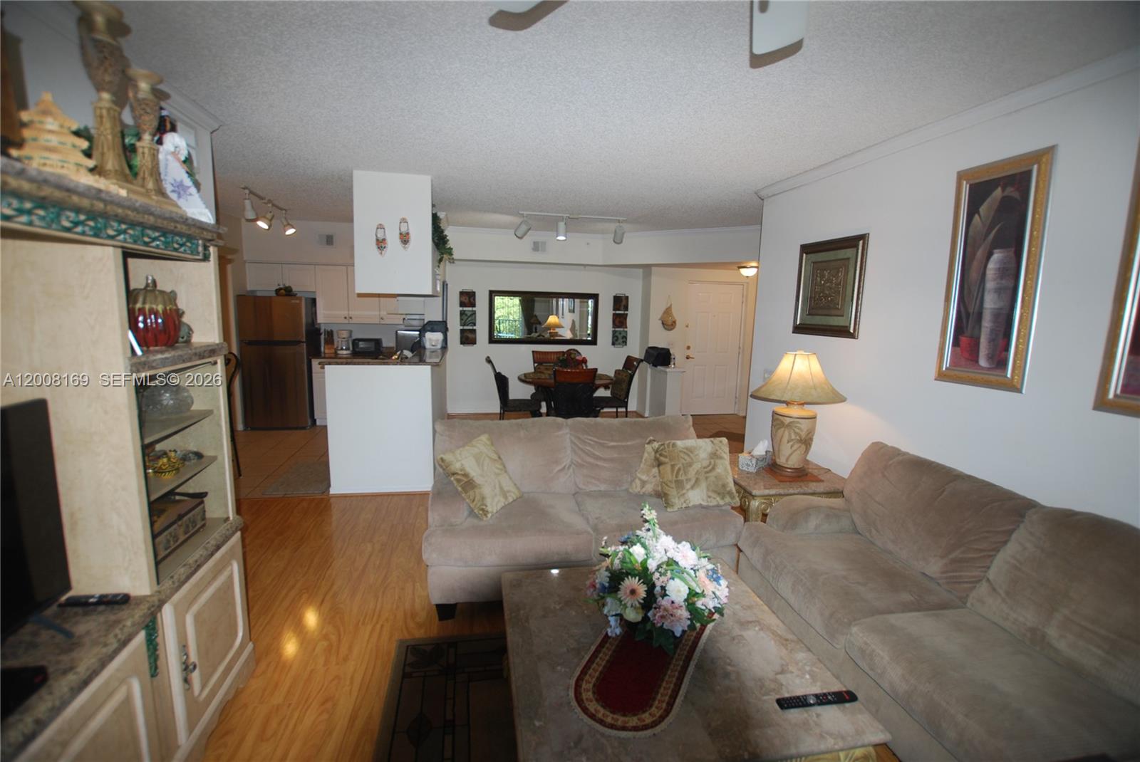 A living room with beige sofas, a coffee table, and an adjacent dining area — 1310 Tuscany Way # 1310, Boynton Beach FL 33435, BOYNTON BEACH, FL