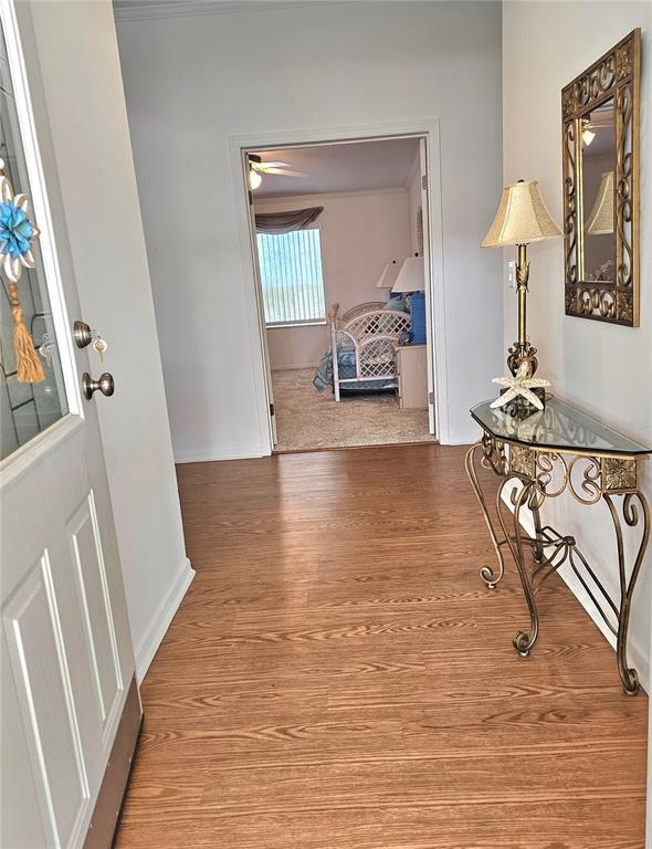 A foyer with wood-look flooring leads to a bedroom through an open doorway — 29 BRINK AVENUE, PUNTA GORDA, FL
