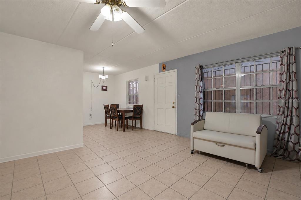 A living and dining area with tiled floors, a white sofa, and a ceiling fan — 4701 CHRISTA COURT UNIT 341, TAMPA, FL