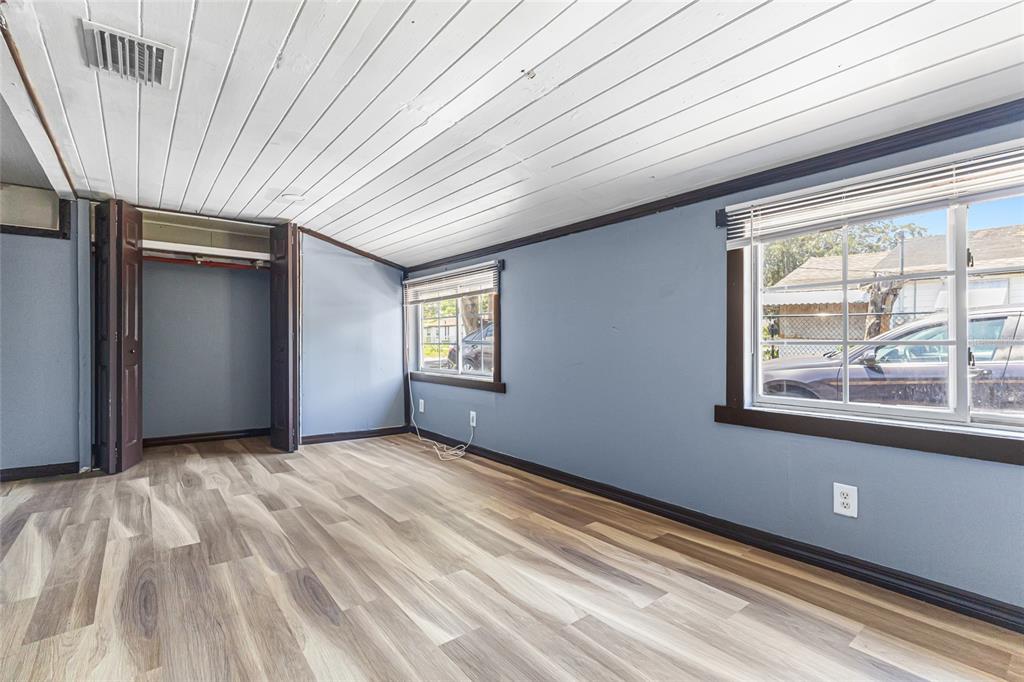 An empty bedroom with blue walls, wood-look flooring, a white plank ceiling, and a closet — 517 OAK STREET, AUBURNDALE, FL