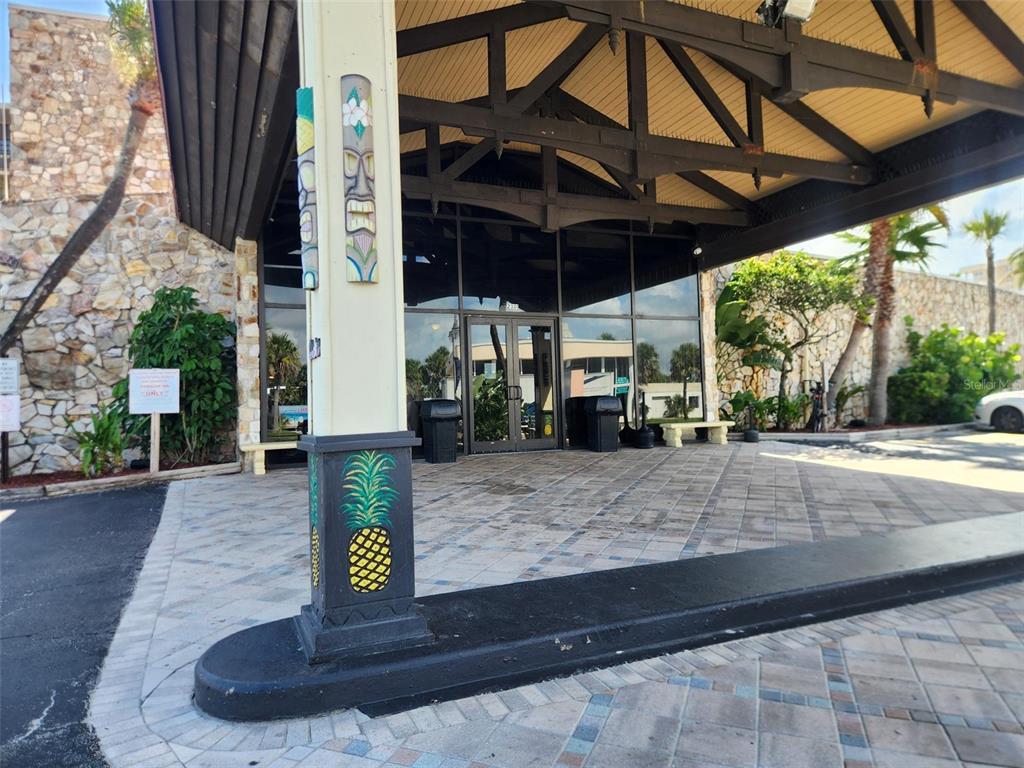 A covered entrance with a stone facade, a pineapple-painted pillar, and glass double doors — 2301 S ATLANTIC AVENUE UNIT 520, DAYTONA BEACH, FL