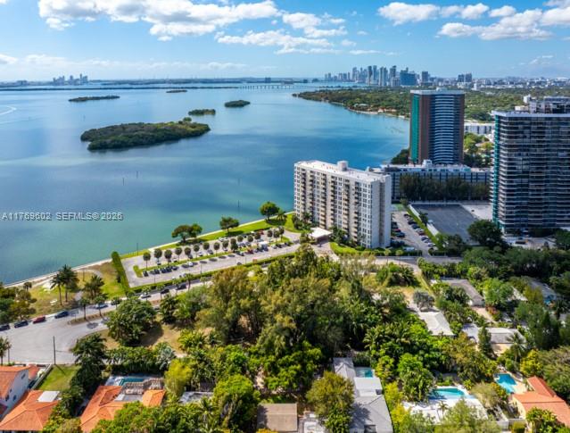 An aerial view shows a waterfront apartment building surrounded by trees and a parking lot — 890 NE 70th St, Miami FL 33138, MIAMI, FL