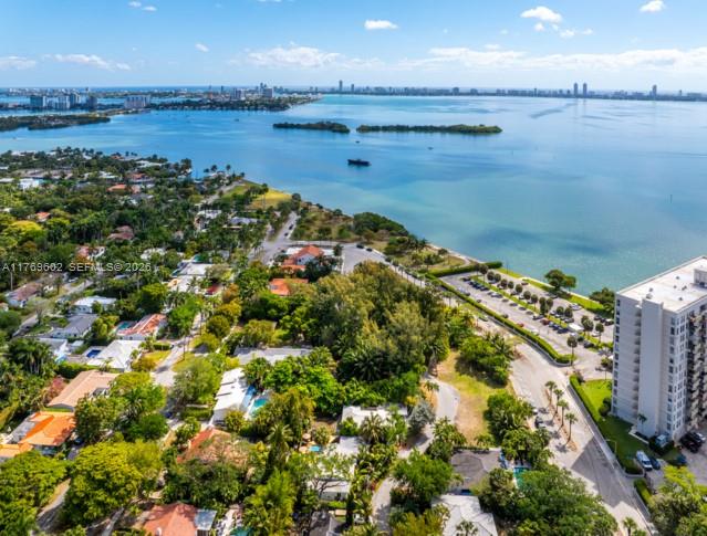 An aerial view shows a coastal neighborhood with houses, trees, and a high-rise building — 890 NE 70th St, Miami FL 33138, MIAMI, FL