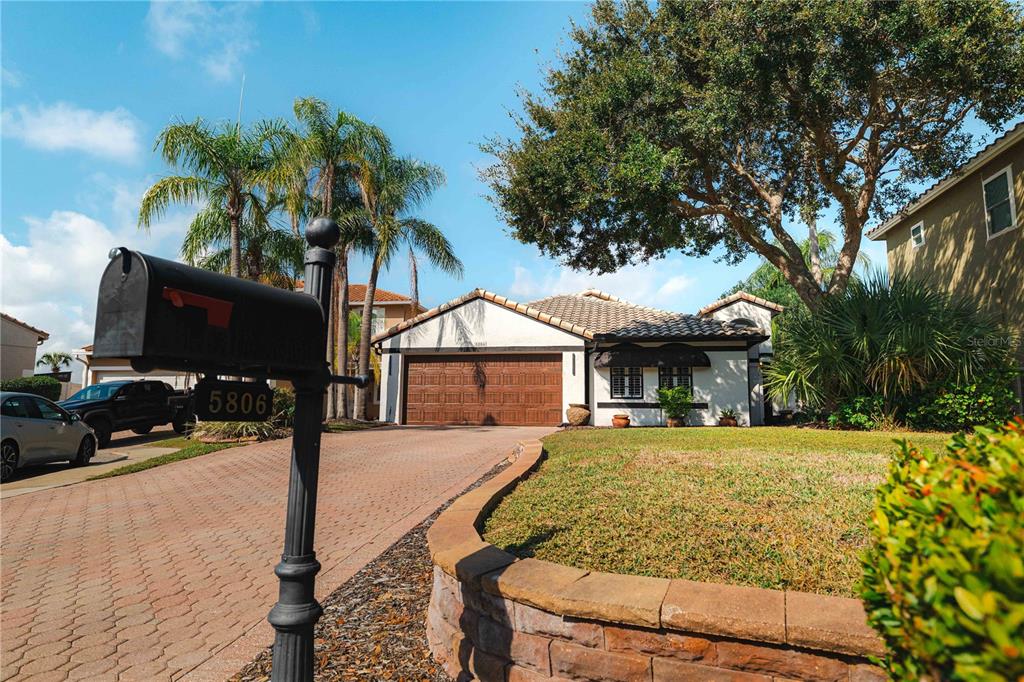 A single-story house with a tiled roof, a two-car garage, and a paved driveway — 5806 CAY COVE COURT, TAMPA, FL