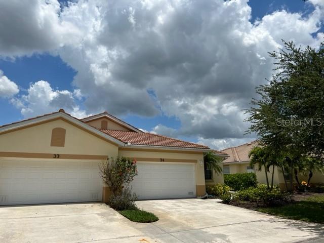 A view of two adjacent residential garage doors with a cloudy sky above — 3181 MATECUMBE KEY ROAD UNIT 34, PUNTA GORDA, FL