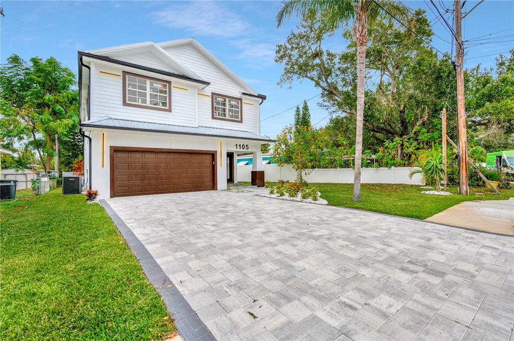 A two-story white house with a brown garage door and a paved driveway — 1105 CONANT AVENUE, SAFETY HARBOR, FL