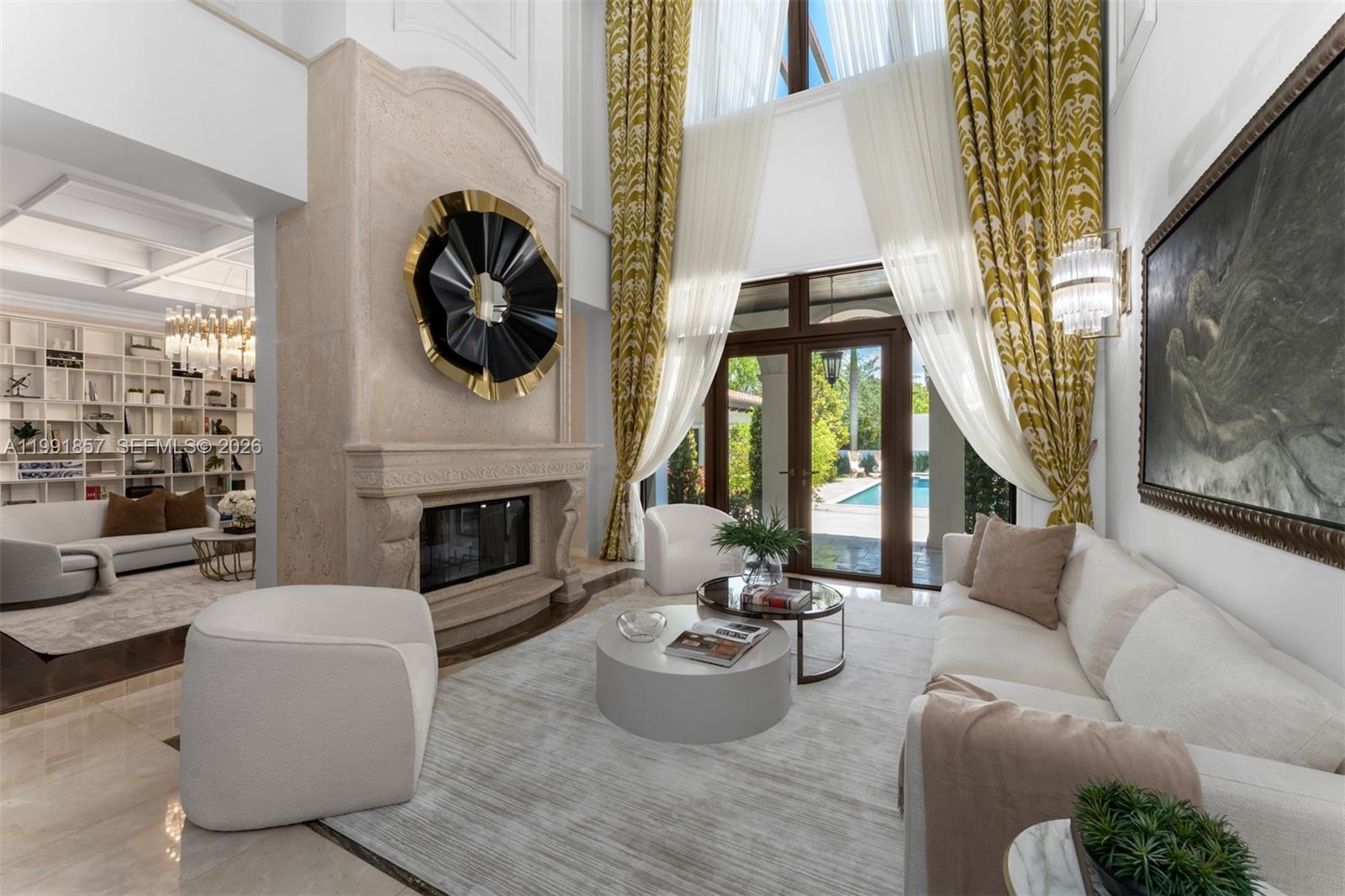 A high-ceilinged living room features a stone fireplace, white furniture, and floor-to-ceiling patterned curtains — 12575 Pine Needle Ln, Pinecrest FL 33156, PINECREST, FL