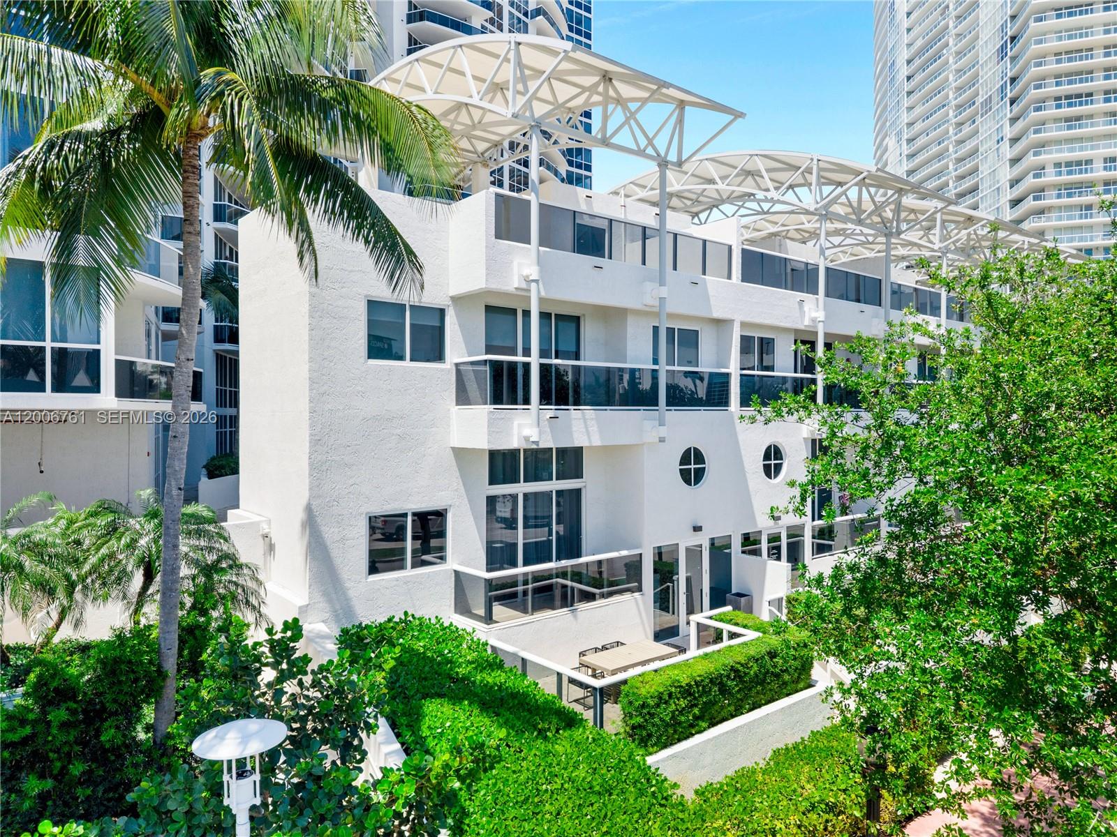 A multi-story white building features balconies, large windows, and a decorative metal roof structure — 400 Alton Rd # 1A, Miami Beach FL 33139, MIAMI BEACH, FL
