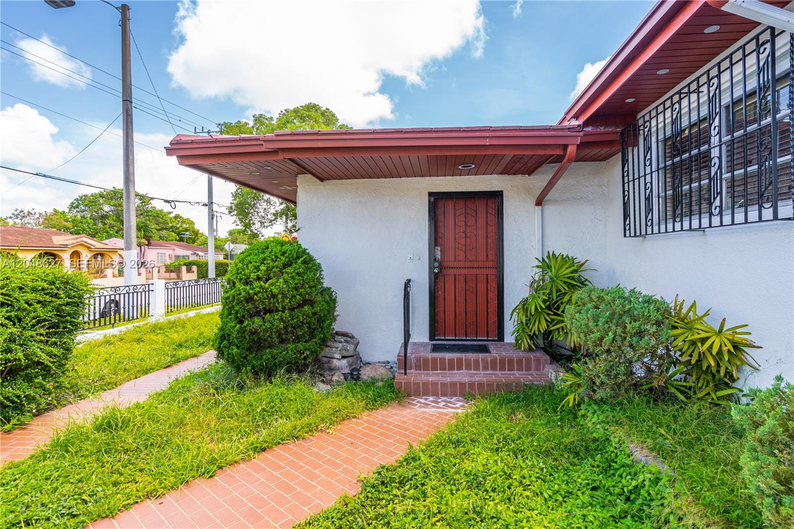 A red brick walkway leads to the front entrance of a white house with security bars — 1841 SW 29th Ave # B, Miami FL 33145, MIAMI, FL