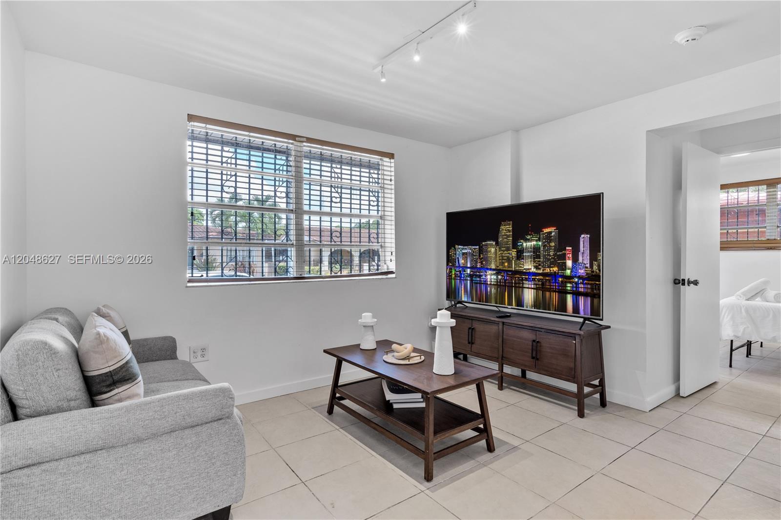 A living room features a gray sofa, a wooden coffee table, and a television console — 1841 SW 29th Ave # B, Miami FL 33145, MIAMI, FL