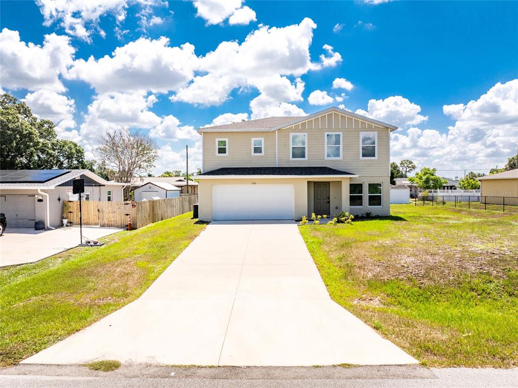 A two-story house with light-colored siding, a two-car garage, and a concrete driveway — 1550 PAXTON TERRACE, PORT CHARLOTTE, FL