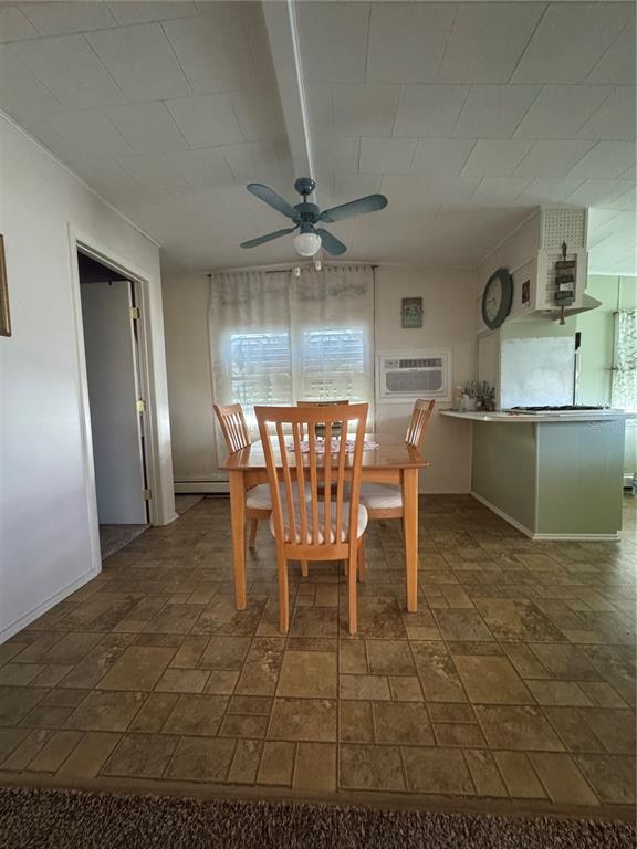 A dining area features a wooden table, four chairs, tile flooring, and a ceiling fan — 118 52ND AVENUE W, BRADENTON, FL