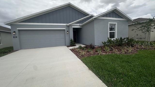 A single-story house with a gray stucco exterior, a two-car garage, and a front lawn — 303 ARTEMIS STREET UNIT 0, LAKE WALES, FL