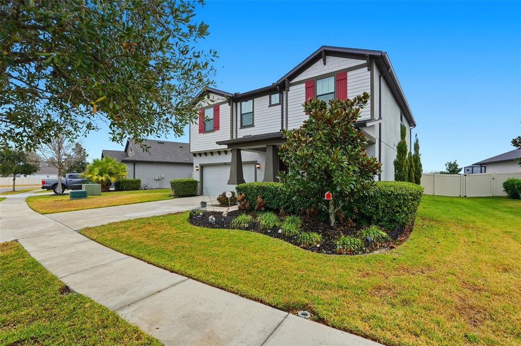 A two-story house with a white facade, red shutters, and a landscaped front yard — 13338 NEWPORT SHORES DRIVE, HUDSON, FL