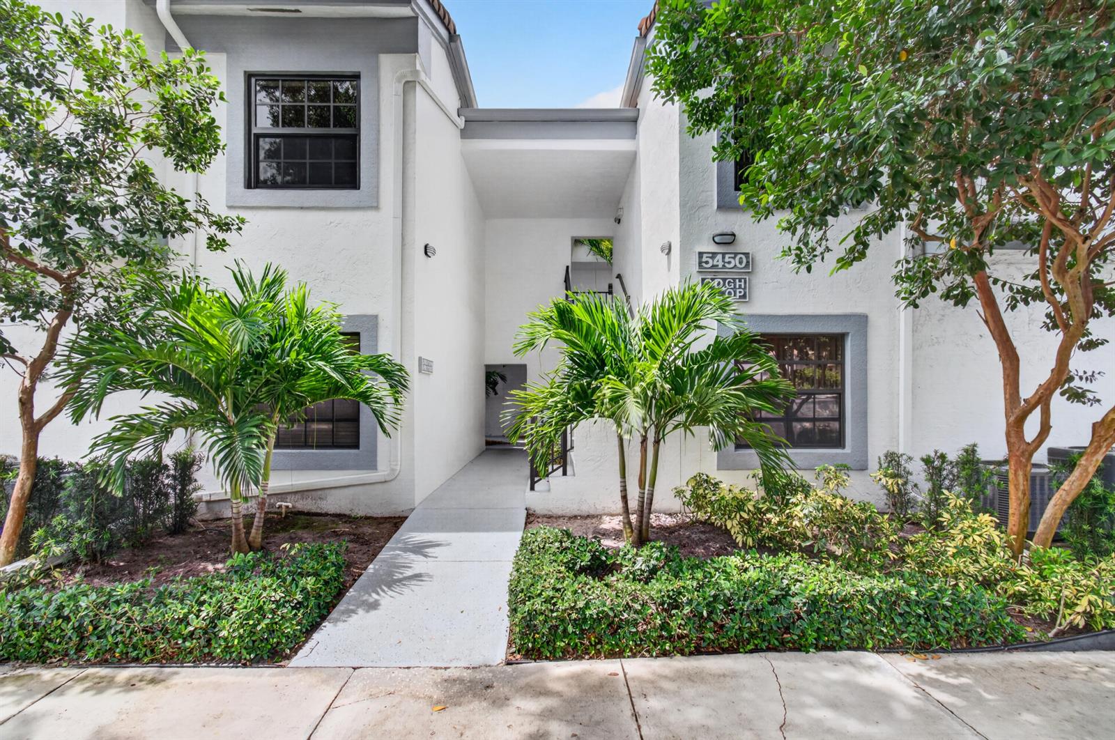 A two-story white stucco building features a central walkway leading to an open stairwell — 5450 Verona Drive # P, Boynton Beach FL 33437, BOYNTON BEACH, FL