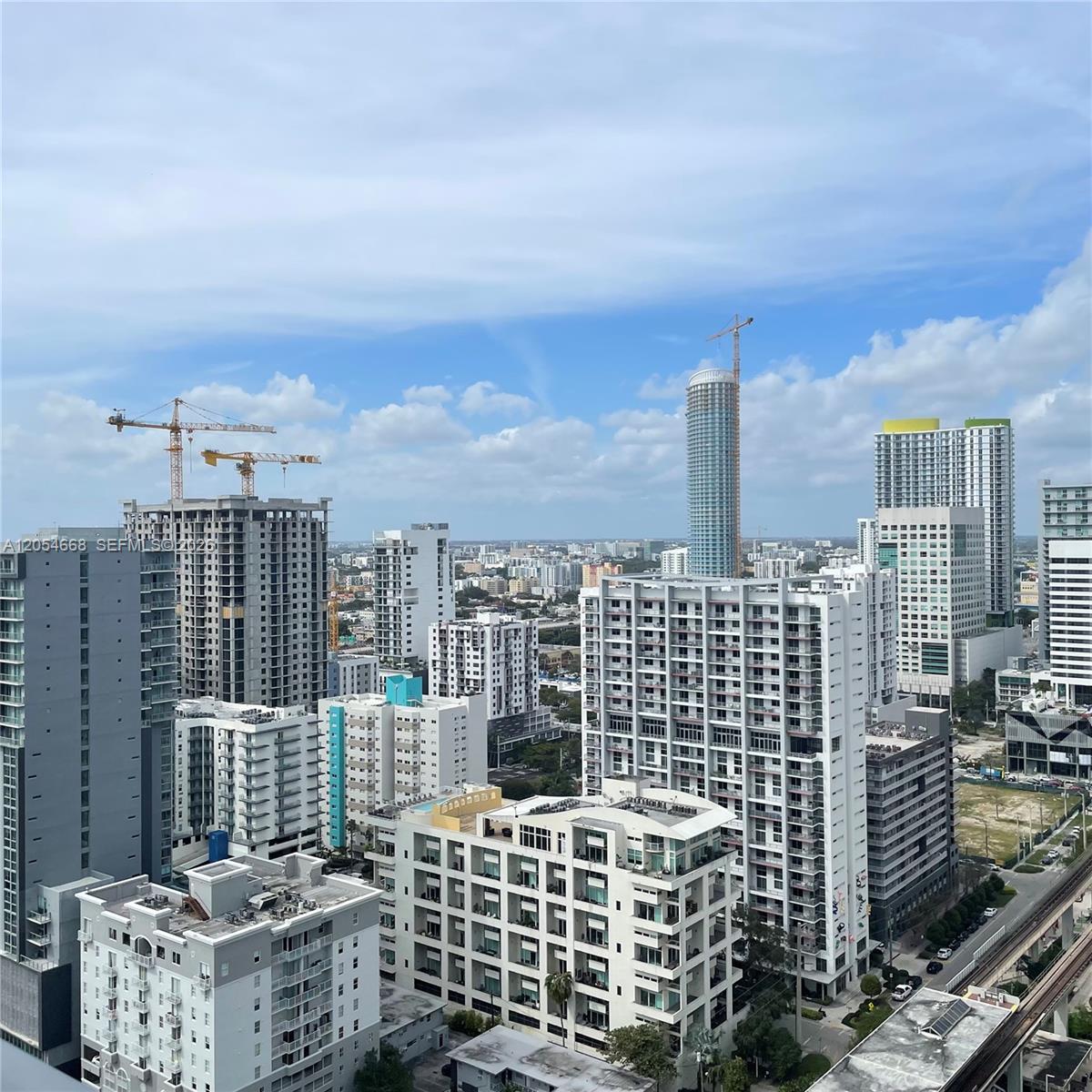 An elevated view of a dense urban skyline featuring multiple high-rise buildings and construction cranes — 79 SW 12 ST, Miami FL 33130, MIAMI, FL