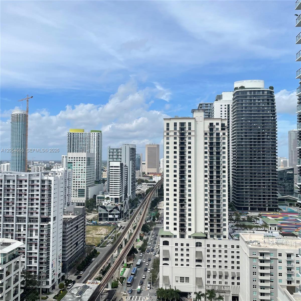 An elevated view of a city skyline featuring high-rise buildings and an elevated train track — 79 SW 12 ST, Miami FL 33130, MIAMI, FL