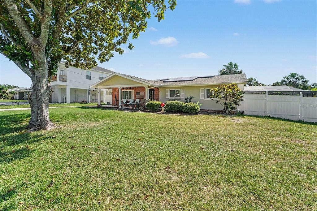 A single-story house with a covered porch, brick accents, and a large front lawn — 8639 GREEN STREET, PORT RICHEY, FL
