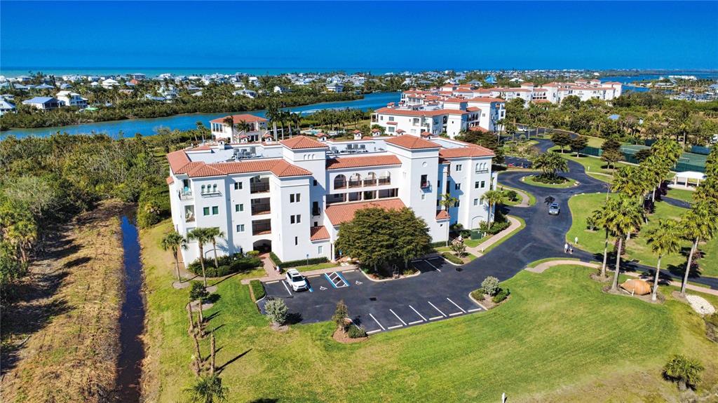 An aerial view shows a multi-story white building with a red tile roof and parking — 11220 HACIENDA DEL MAR BOULEVARD UNIT 204, PLACIDA, FL