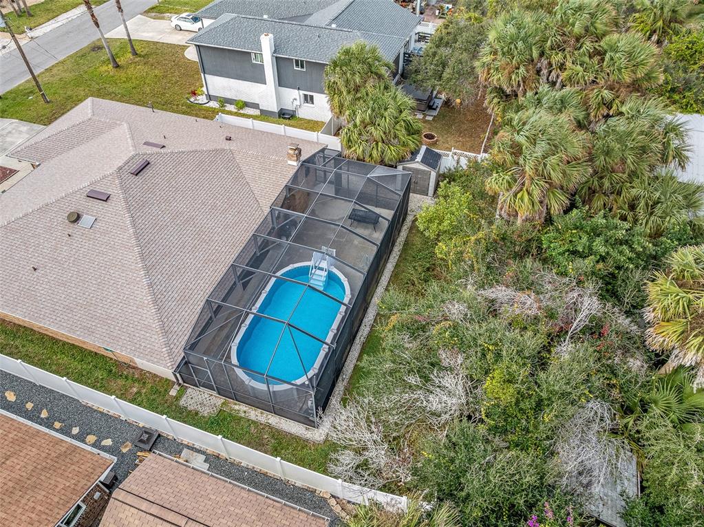 An aerial view shows a house with a screened-in pool enclosure and a backyard — 2008 N DAYTONA AVENUE, FLAGLER BEACH, FL
