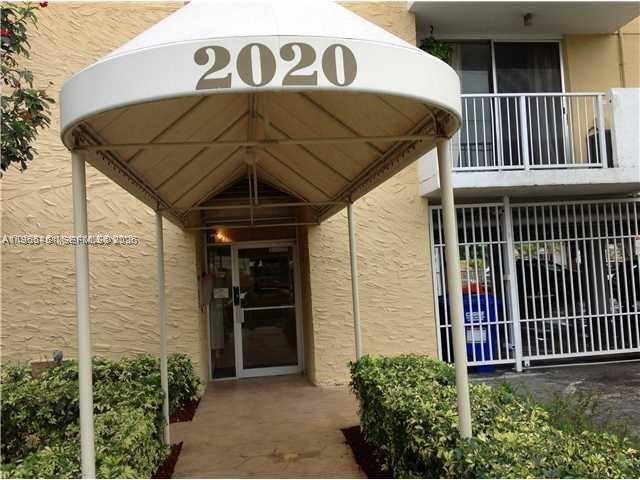 An exterior view of a building entrance with a white awning labeled 2020 — 2020 NE 135th St # 901, North Miami FL 33181, NORTH MIAMI, FL