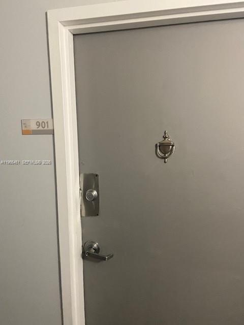 A gray apartment door features a silver handle, a deadbolt, and a decorative door knocker — 2020 NE 135th St # 901, North Miami FL 33181, NORTH MIAMI, FL