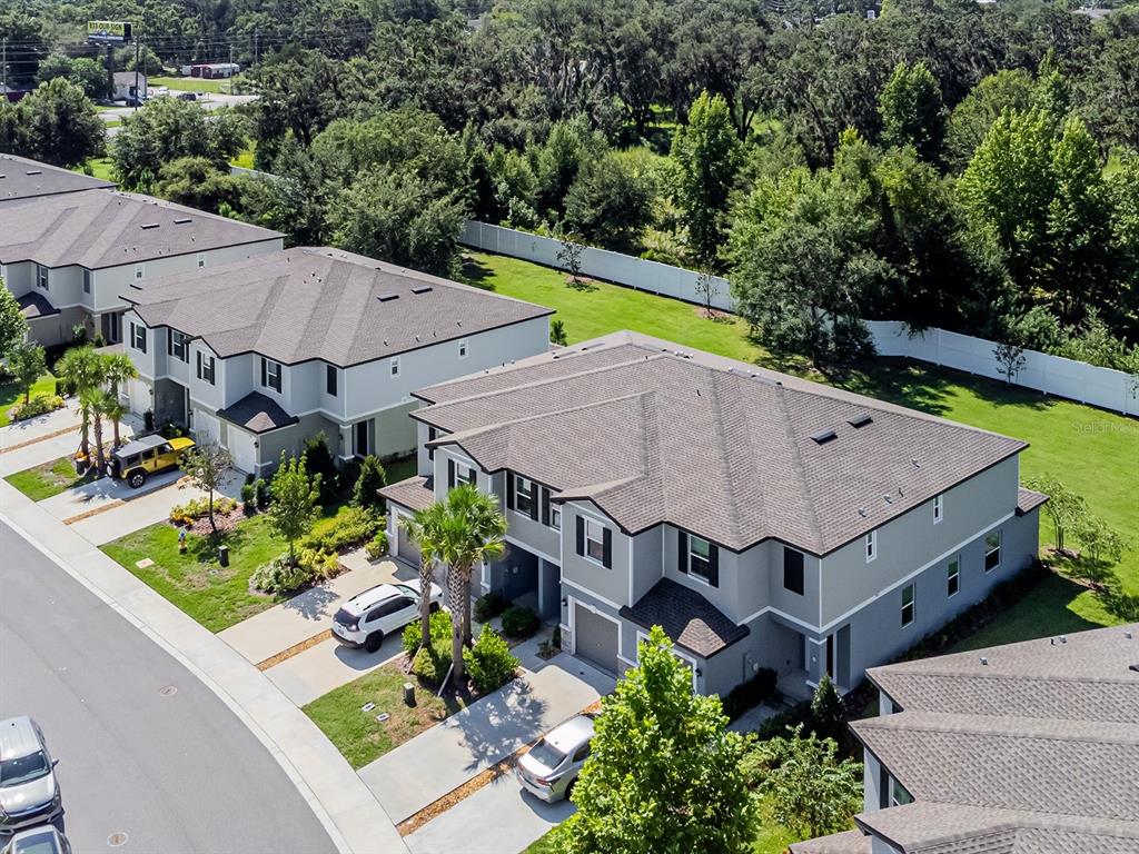 An aerial view shows several two-story townhomes with gray siding and asphalt shingle roofs — 21372 DARTER ROAD, LAND O LAKES, FL