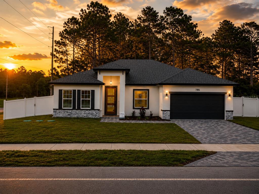 A single-story house with a dark roof, white stucco walls, and a two-car garage — 785 MARION OAKS TRL UNIT 785, OCALA, FL