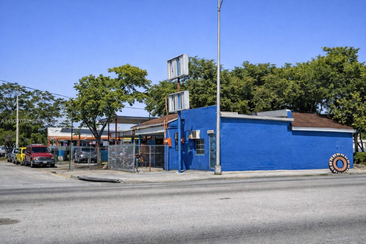 A bright blue commercial building stands on a corner lot with a large tire sign — 1650 NW 27th Ave, Miami FL 33125, MIAMI, FL