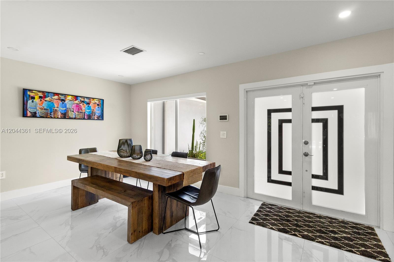 A dining room features a rustic wooden table, matching bench, black chairs, and double doors — 12900 SW 112th Ave, Miami FL 33176, MIAMI, FL