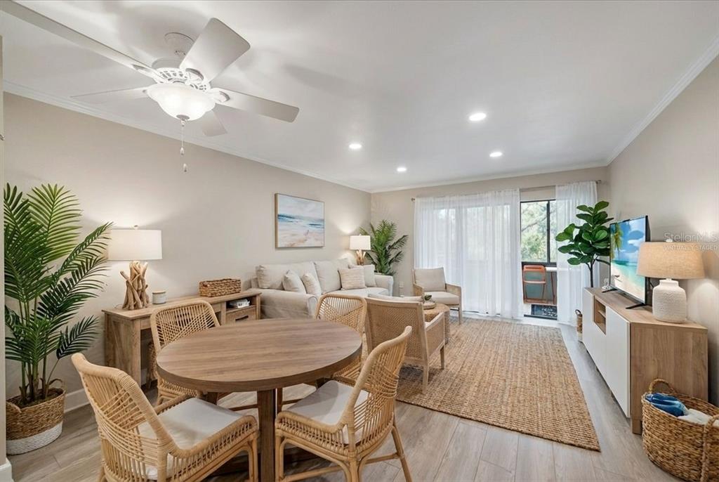 A living and dining area features light wood flooring, a ceiling fan, and coastal-style furniture — 257 SHERWOOD DRIVE UNIT 257, BRADENTON, FL