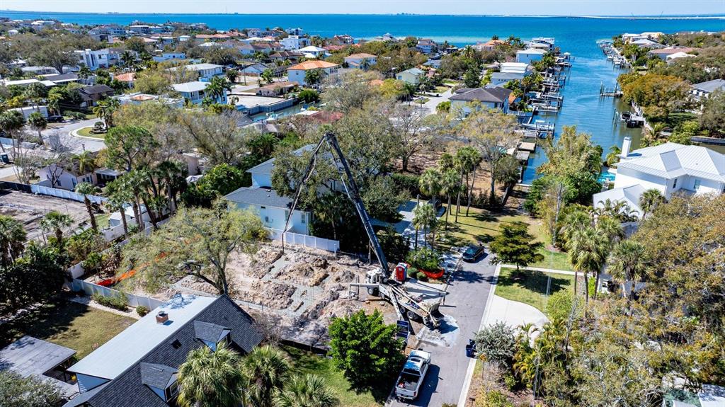 An aerial view shows a concrete pump truck pouring foundation footings at a residential construction site — 4906 W ESTRELLA STREET, TAMPA, FL