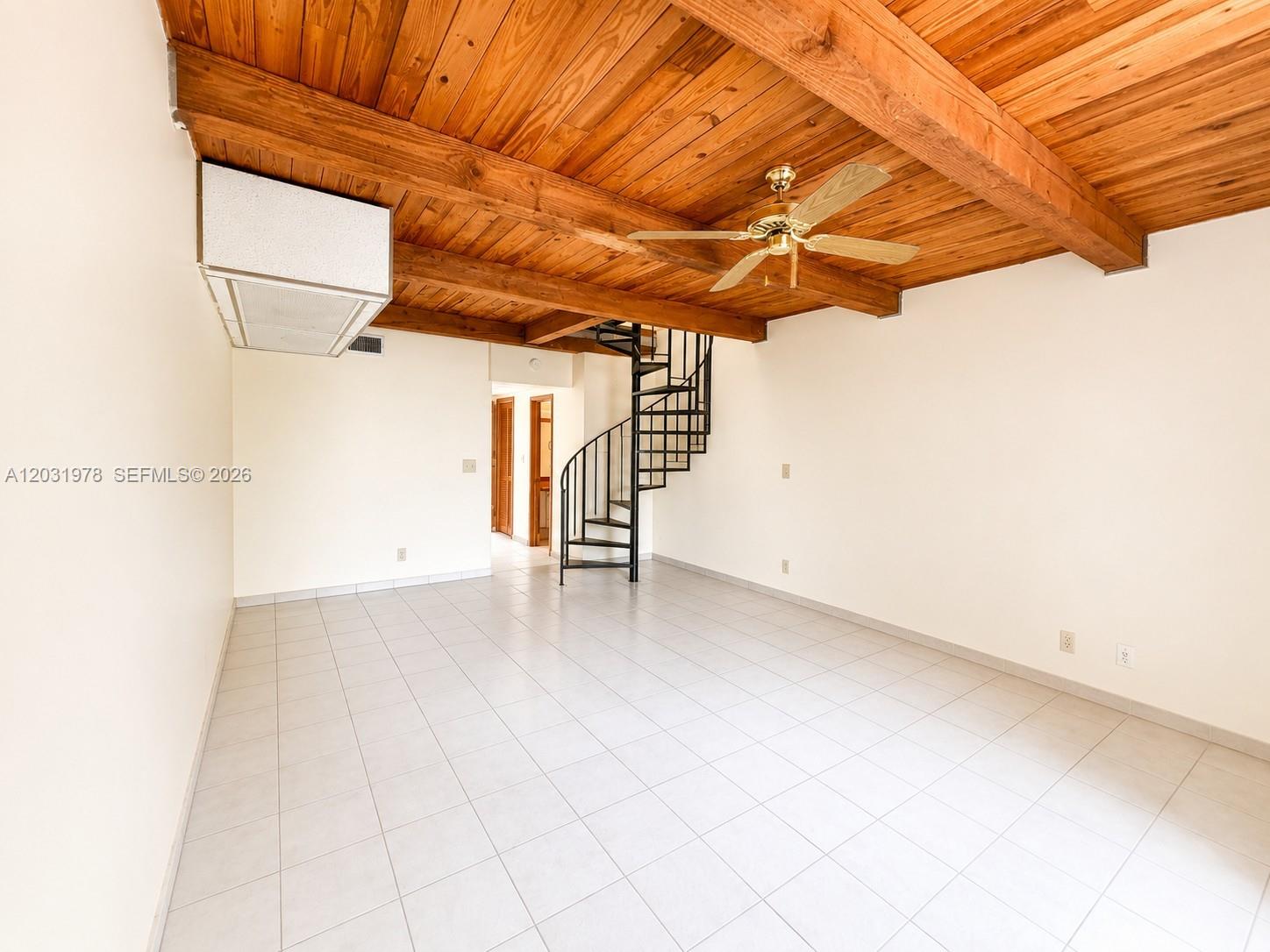 A room with white tile floors, a wood-beamed ceiling, and a black spiral staircase — 3719 Riverside Dr, Coral Springs FL 33065, CORAL SPRINGS, FL