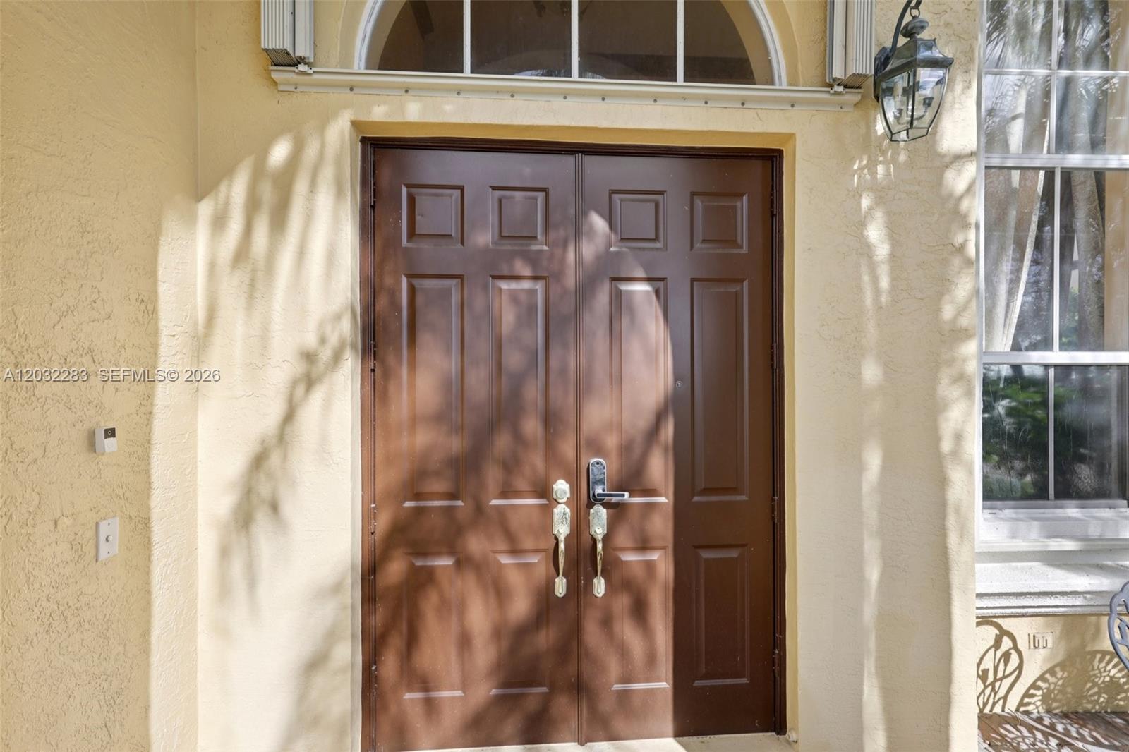 A brown double front door with a transom window is set in a stucco wall — 16479 SW 54th Ct, Miramar FL 33027, MIRAMAR, FL