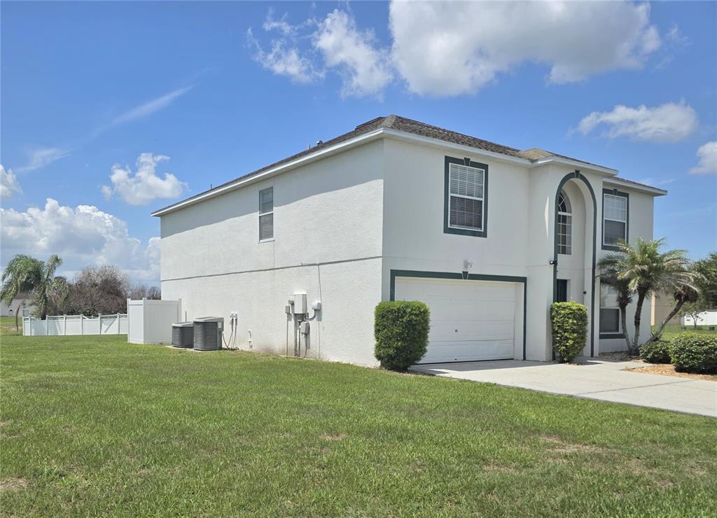 A two-story white stucco house with a garage and a large grassy yard — 145 VISTA VIEW AVENUE, EAGLE LAKE, FL