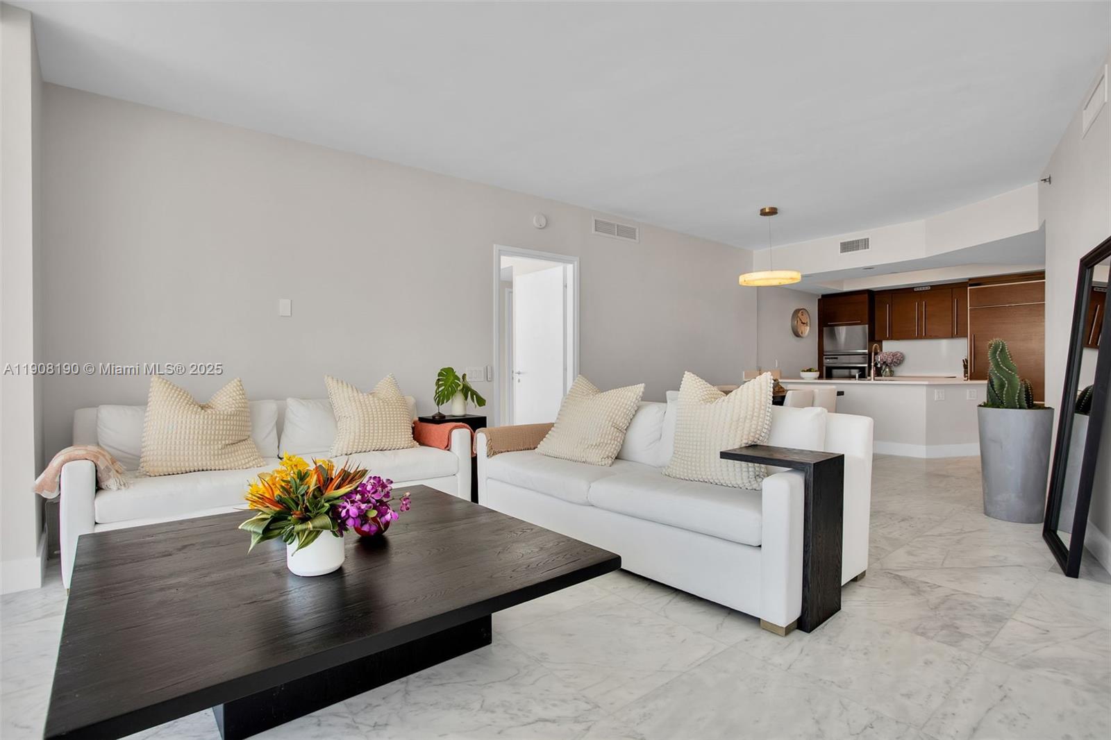 A living room features two white sofas, a dark wood coffee table, and marble flooring — 450 Alton Rd # 2110, Miami Beach FL 33139, MIAMI BEACH, FL