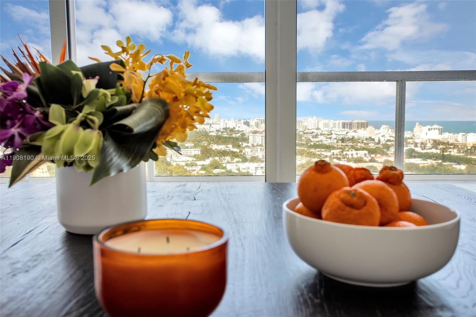 A bowl of oranges and a flower vase sit on a table before a window — 450 Alton Rd # 2110, Miami Beach FL 33139, MIAMI BEACH, FL