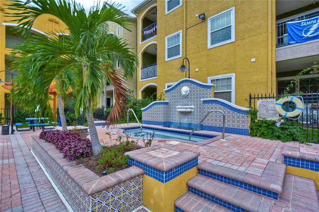 An outdoor hot tub with a tiled fountain feature sits on a brick patio — 1910 E PALM AVENUE UNIT 11117, TAMPA, FL