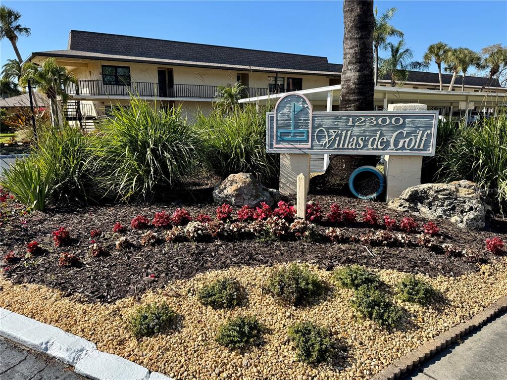 An exterior view of a multi-story apartment building with a Villas de Golf sign — 12300 VONN ROAD UNIT 5304, LARGO, FL