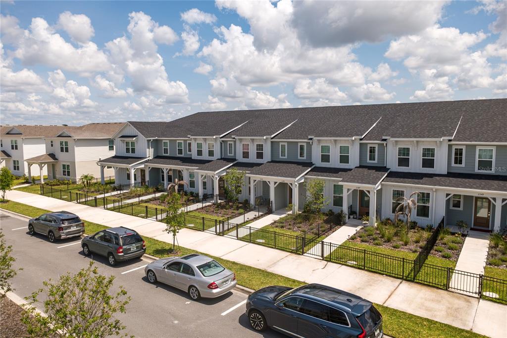 An exterior view of a row of modern townhomes with parked cars along the street — 2345 SOUTHBURY, KISSIMMEE, FL