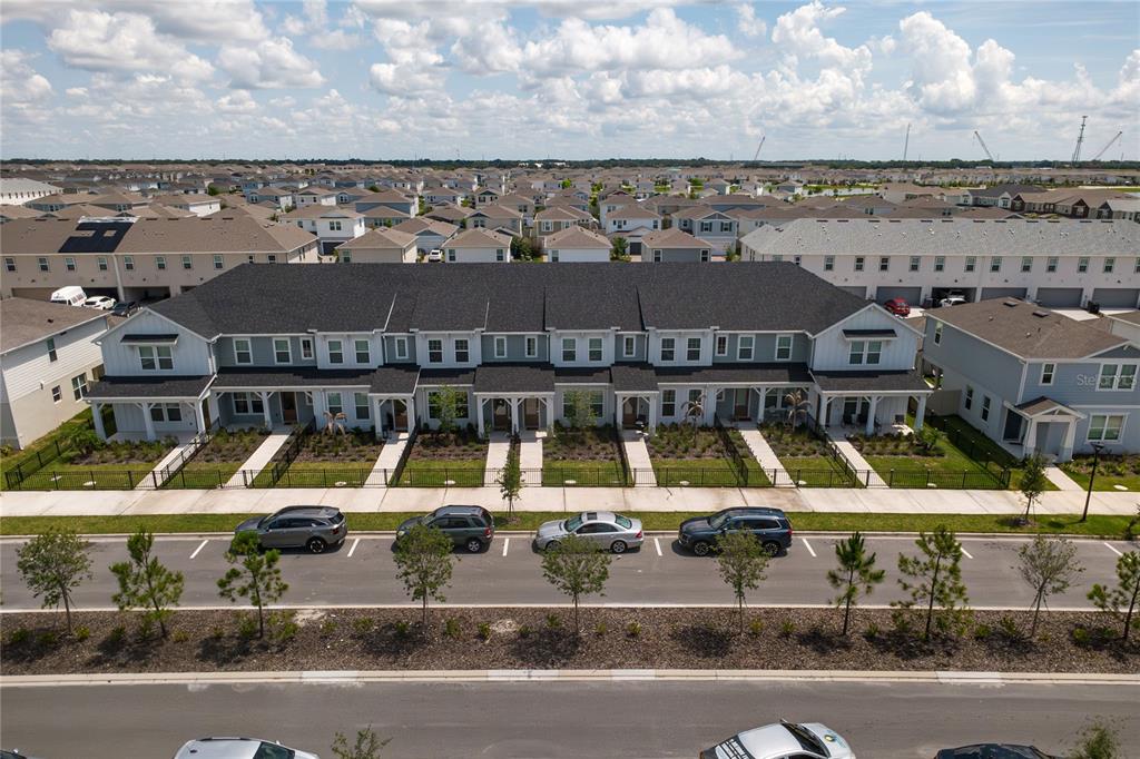 An aerial view of a multi-unit townhouse building with a dark roof and landscaping — 2345 SOUTHBURY, KISSIMMEE, FL