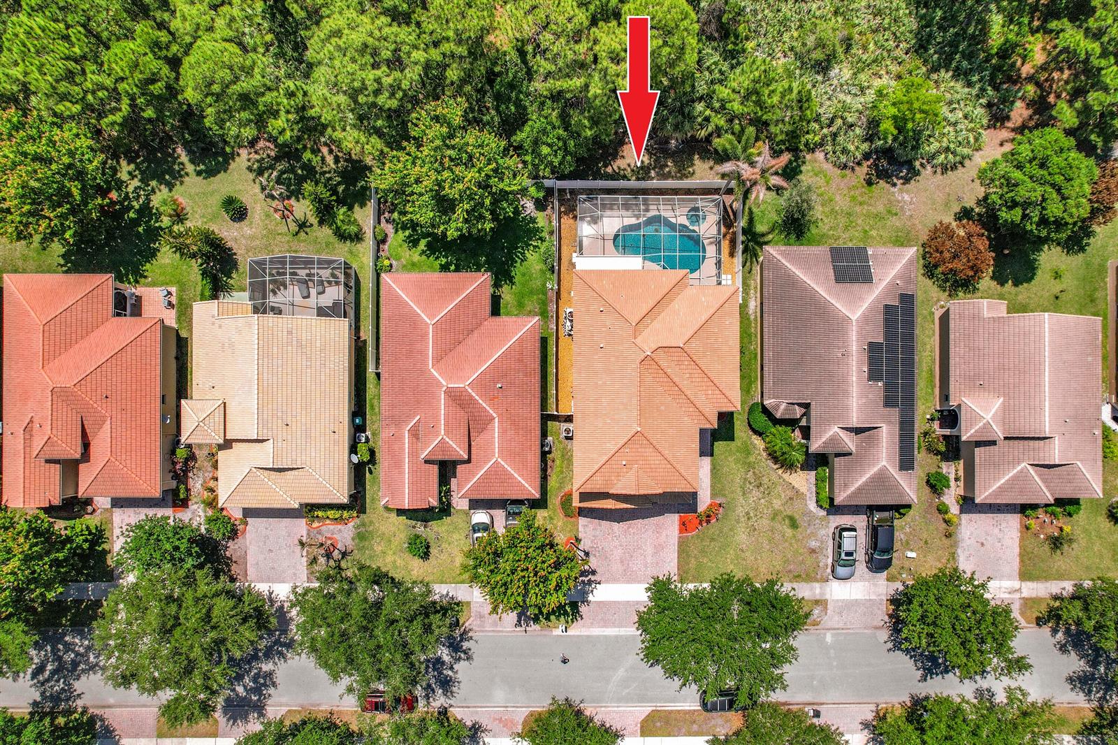 An aerial view shows a suburban neighborhood with houses, swimming pools, and surrounding trees — 5747 Sunberry Circle, Fort Pierce FL 34951, FORT PIERCE, FL