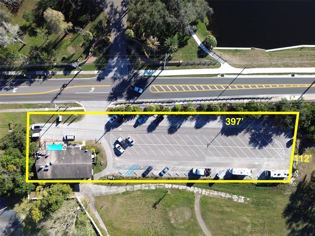 This aerial view shows a commercial property with a building and a paved parking lot — 1200 8TH AVENUE SW UNIT 1, LARGO, FL