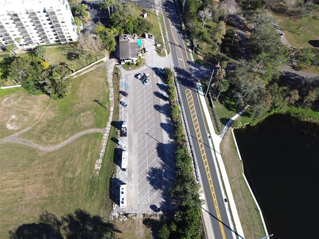 An aerial view shows a parking lot with several vehicles next to a road and lake — 1200 8TH AVENUE SW UNIT 1, LARGO, FL