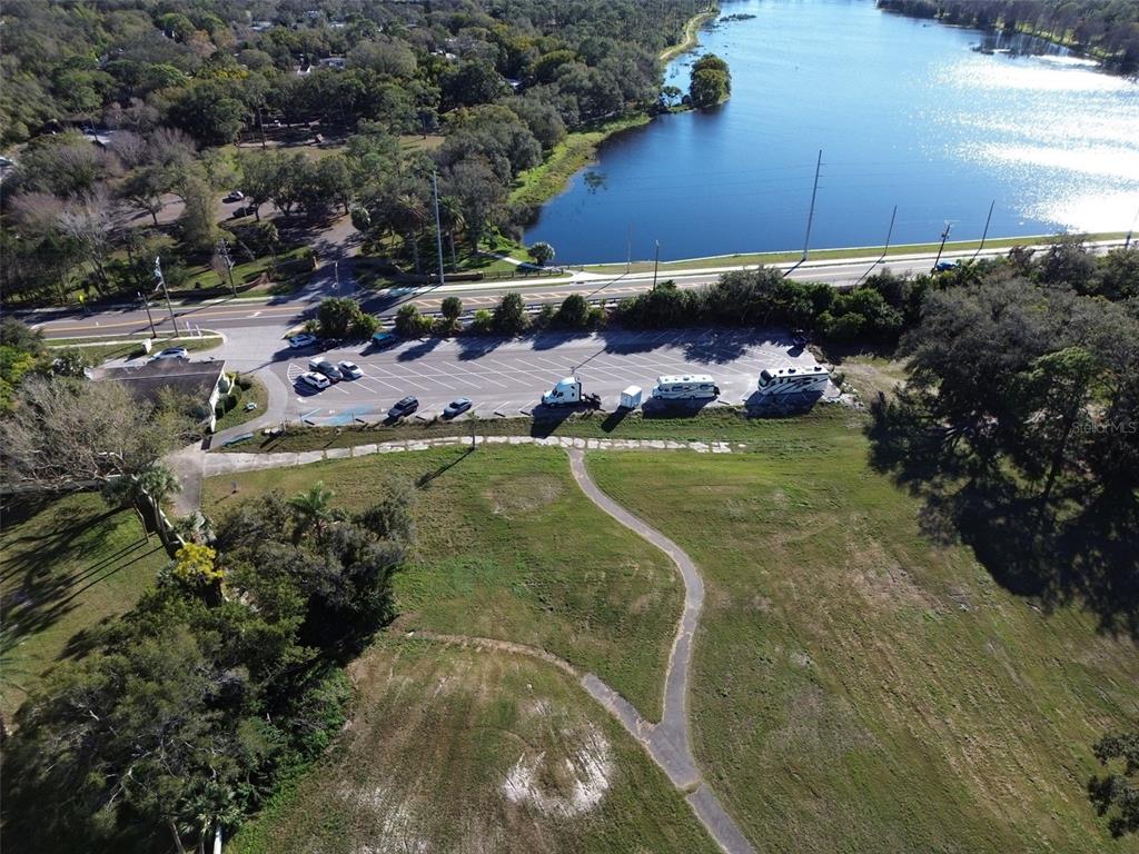 An aerial view shows a parking lot, a grassy field, and a lake — 1200 8TH AVENUE SW UNIT 1, LARGO, FL