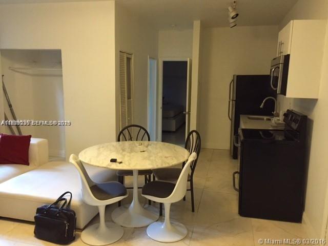 A small dining area with a round table and chairs sits next to a kitchen — 842 Meridian Ave # 1B, Miami Beach FL 33139, MIAMI BEACH, FL
