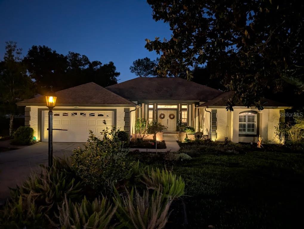 A screened-in pool area features a stone fountain, lounge chairs, and a golf course view — 39819 GROVE HEIGHTS, LADY LAKE, FL